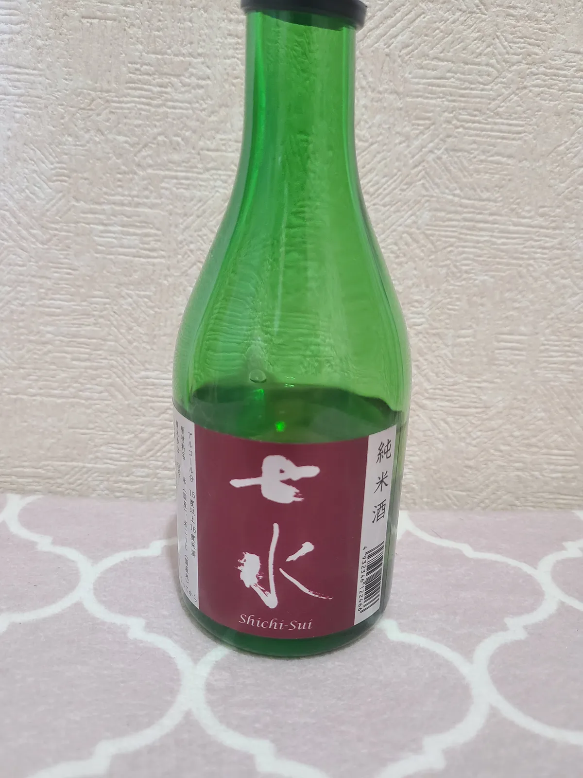 七水の純米酒。緑色のボトルに赤色のラベルが映える外観