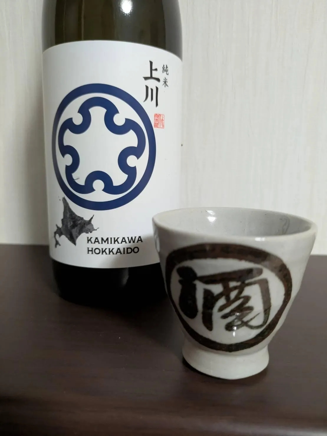 白いラベルに紺色のロゴが映える上川純米のボトルと酒器