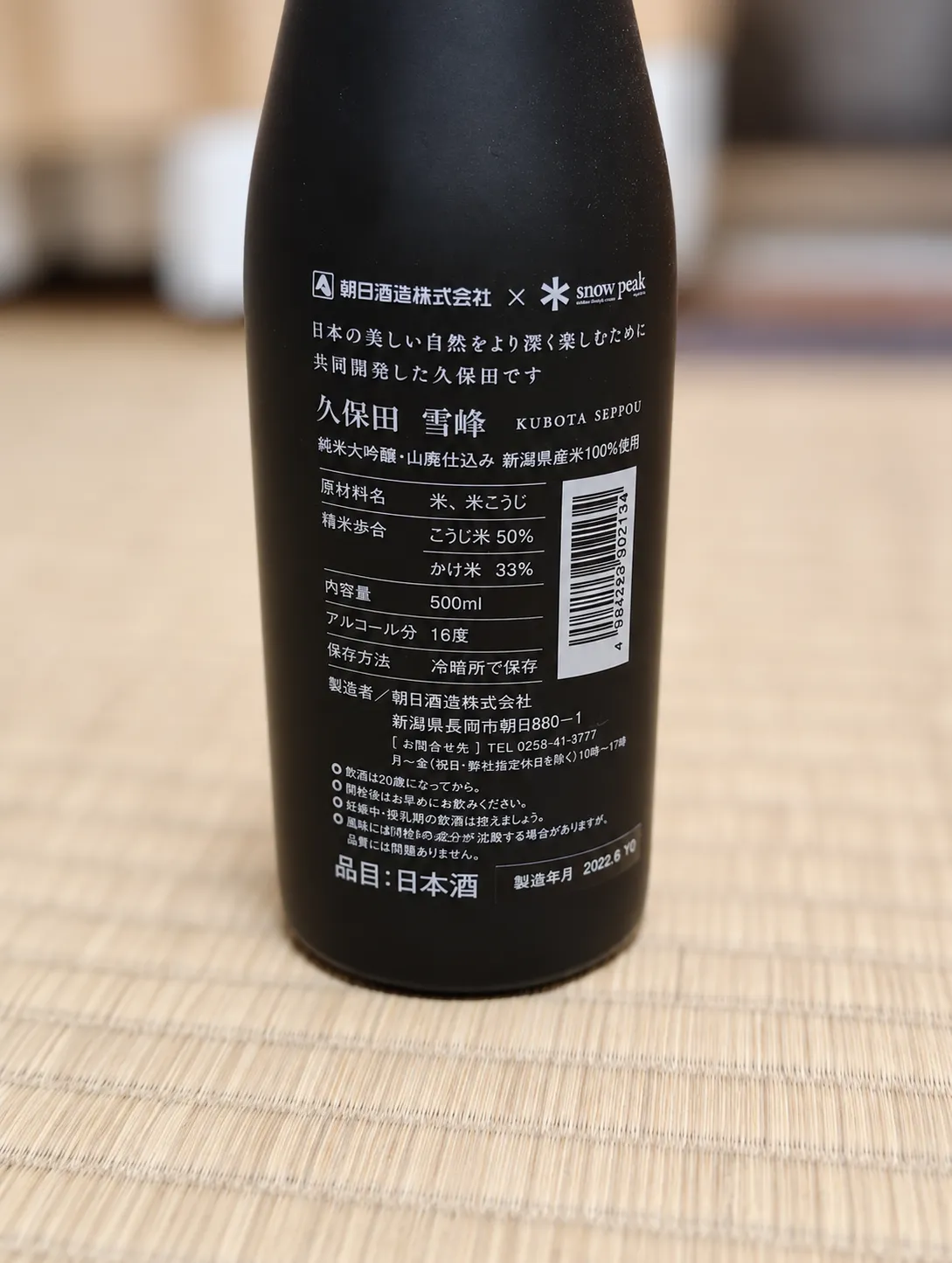 久保田 雪峰の裏ラベル。朝日酒造とsnow peakのロゴやスペックが記載されている