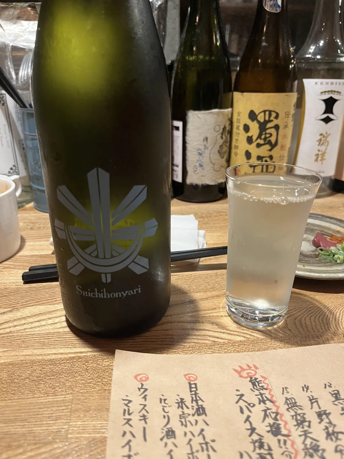 結露した七本鎗のボトルと、グラスに注がれたお酒